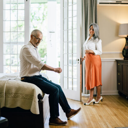 A man sitting on the end of the bed at The Charles Hotel in Niagara-on-the-Lake.