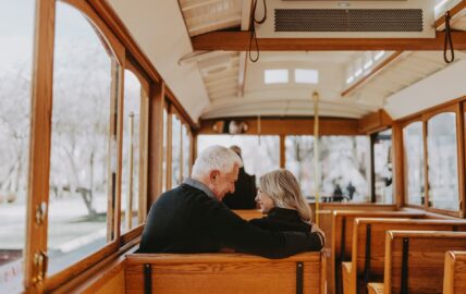 A couple sitting on a trolley as part of the Suds and Spirits Trolley Tour.