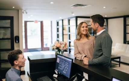 A couple a the reservation desk at the Shaw Club Hotel in Niagara-on-the-Lake