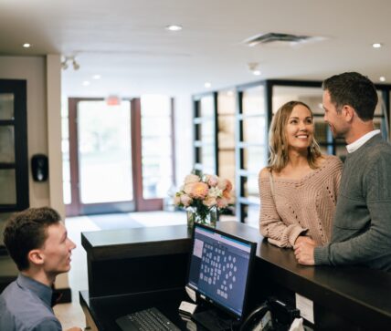 A couple a the reservation desk at the Shaw Club Hotel in Niagara-on-the-Lake