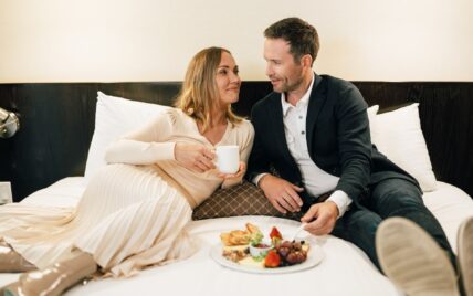 Couple lounging on the bed at the Shaw Club Hotel, Niagara-on-the-Lake