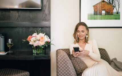 Women lounging on the sofa looking at her mobile phone at the Shaw Club Hotel, Niagara-on-the-Lake